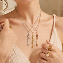 Model styling a gold heart Y necklace with layered chains at the neckline