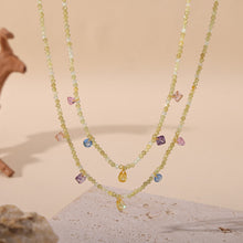 Layered natural stone necklaces with colorful beads arranged in a boutique jewelry display
