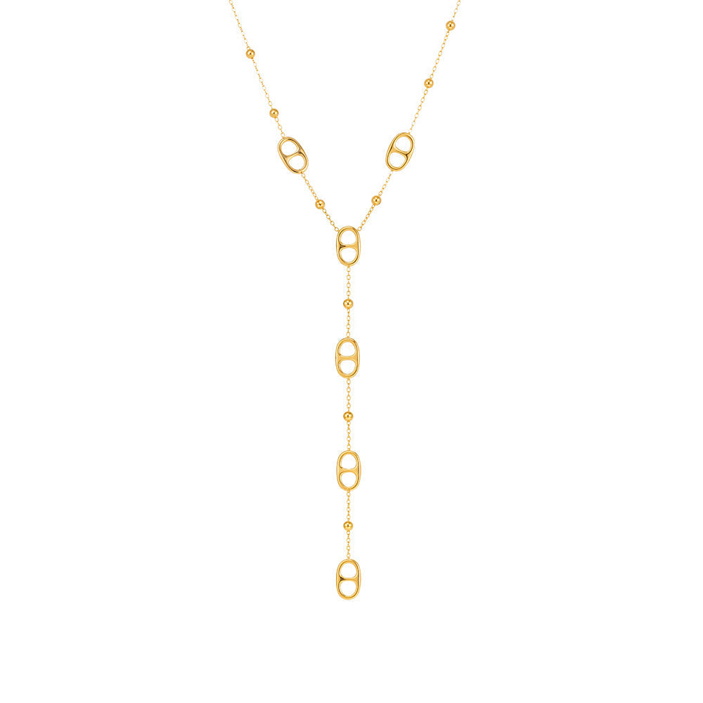 Gold tone layered stainless steel tassel necklace with long geometric drop chain on white background