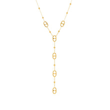 Gold tone layered stainless steel tassel necklace with long geometric drop chain on white background