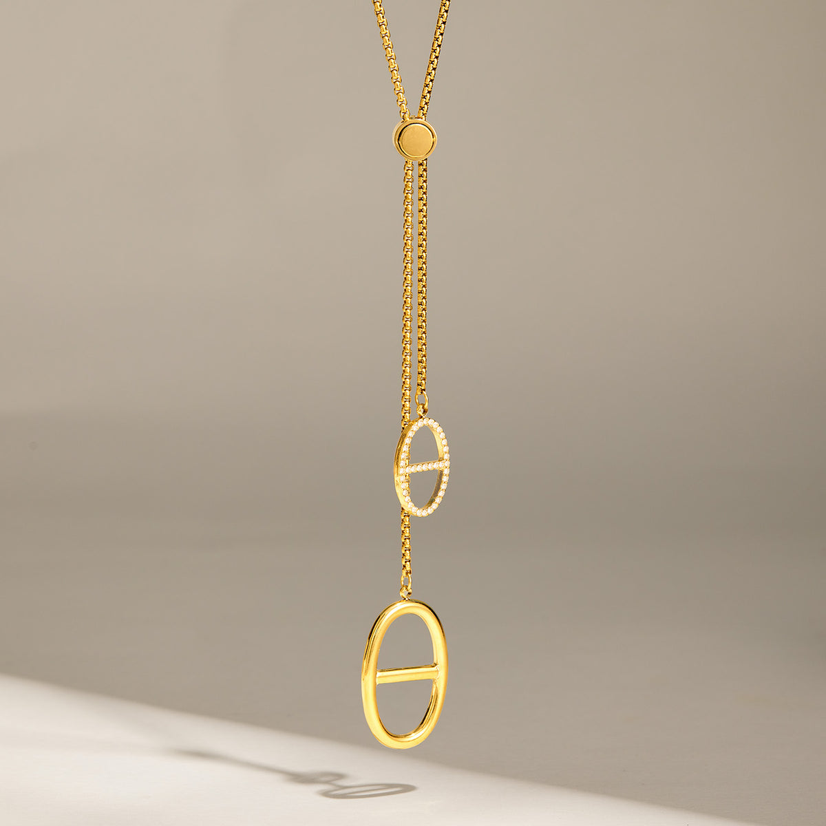 Long geometric zircon lariat necklace with 18K gold PVD finish and vertical drop design