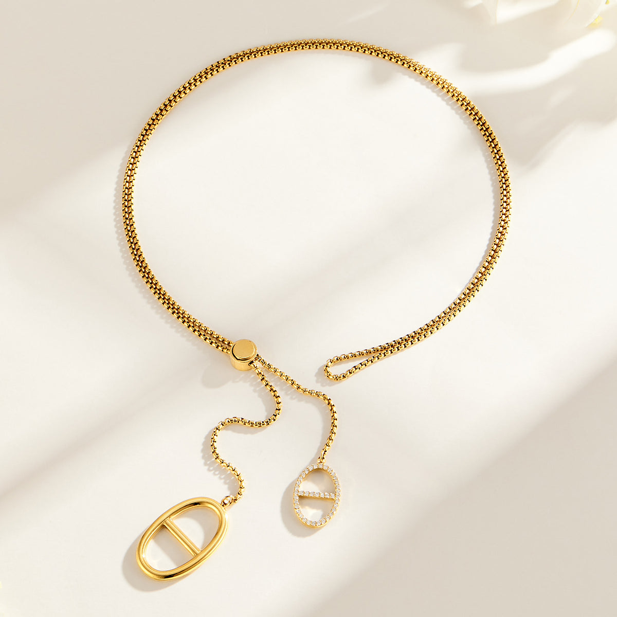 Long gold zircon lariat necklace with extended drop chain and geometric link pendants