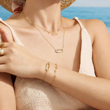 Model styling a delicate MAMA necklace and matching bracelet with crossed arms