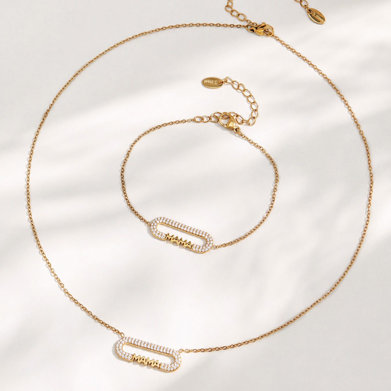 MAMA zircon bar necklace and matching bracelet arranged in a circular flat lay