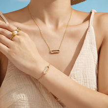 Model styling a gold MAMA zircon necklace with the matching letter bracelet