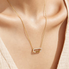 Close-up of a gold MAMA zircon bar necklace worn at the neckline