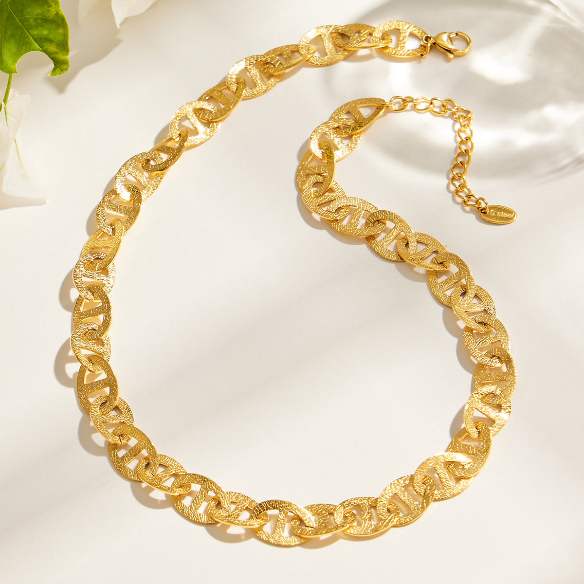 Gold mariner chain necklace flat lay with oval center-bar links