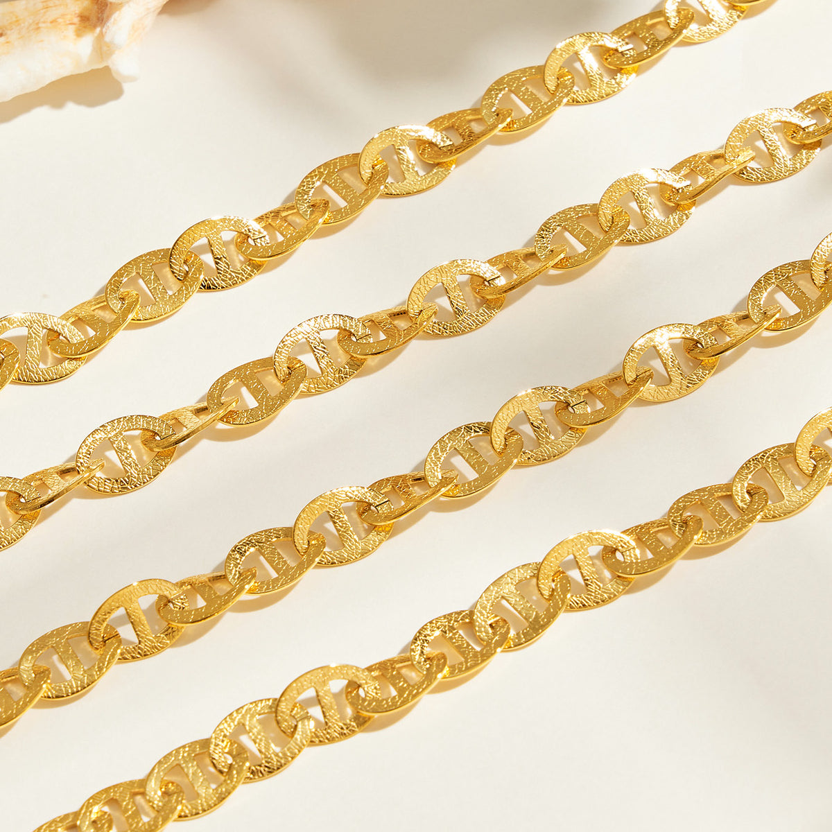 Close-up of gold mariner chain links with center-bar design
