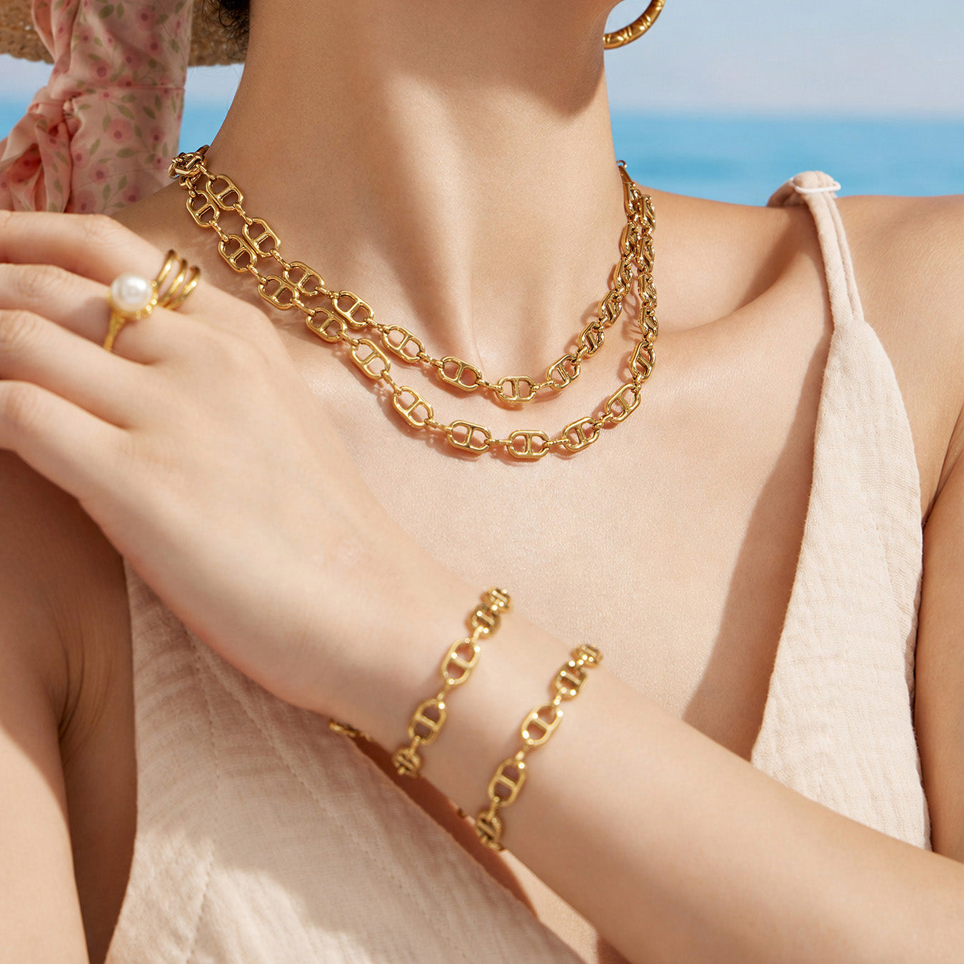 Model styling a gold mariner necklace and matching oval link bracelet