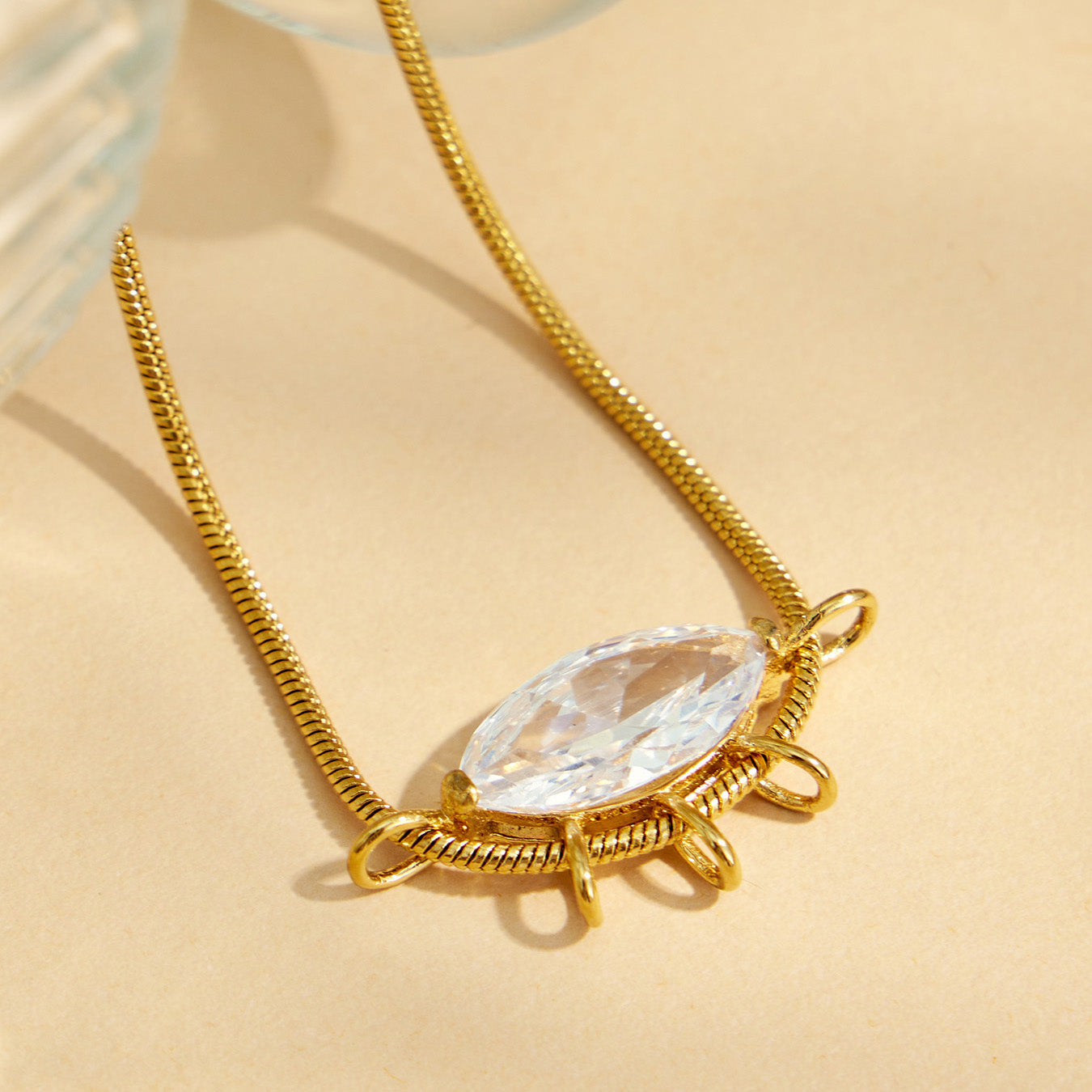 Close-up of a marquise zircon pendant set horizontally on a gold-tone chain