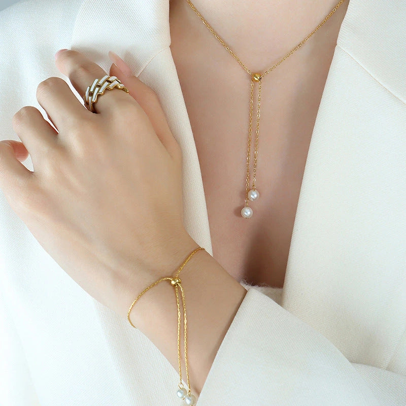 Matching gold pearl lariat necklace and slider bracelet lifestyle view