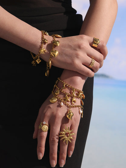 Layered beach styling with shell charm bracelet stack, conch pearl anklet and gold rings for resort boutique jewelry