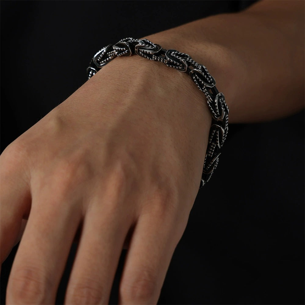 Men's black chain bracelet worn on wrist with bold streetwear styling and stainless steel finish