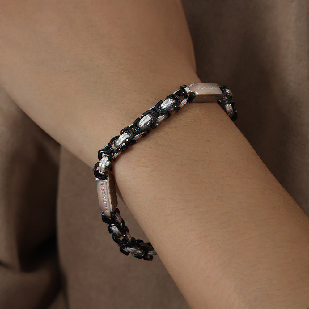 Side wrist view of men’s black steel link bracelet showing heavy chain structure and stainless steel finish