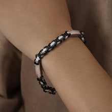 Side wrist view of men’s black steel link bracelet showing heavy chain structure and stainless steel finish