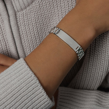 Men’s steel tone ID link bracelet on wrist with watch-band-style links and polished stainless steel finish