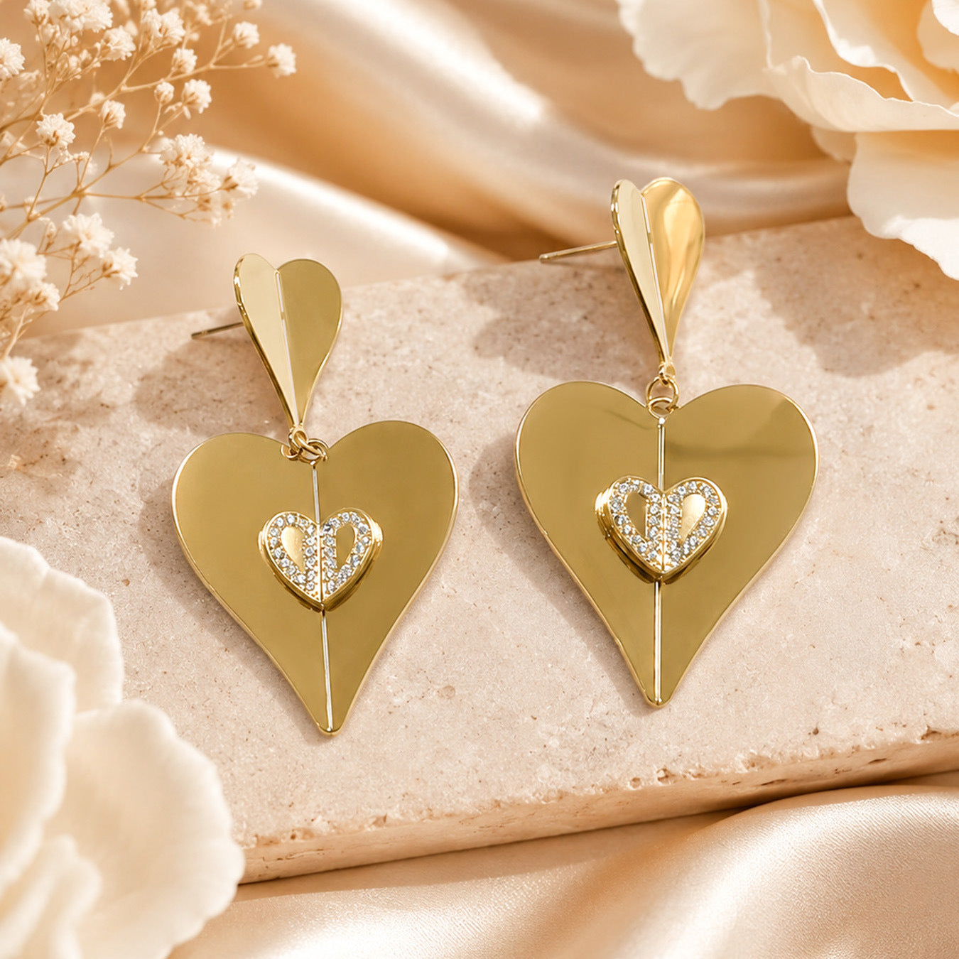Close up of gold heart zircon drop earrings with micro pave zircon accents and double heart charm