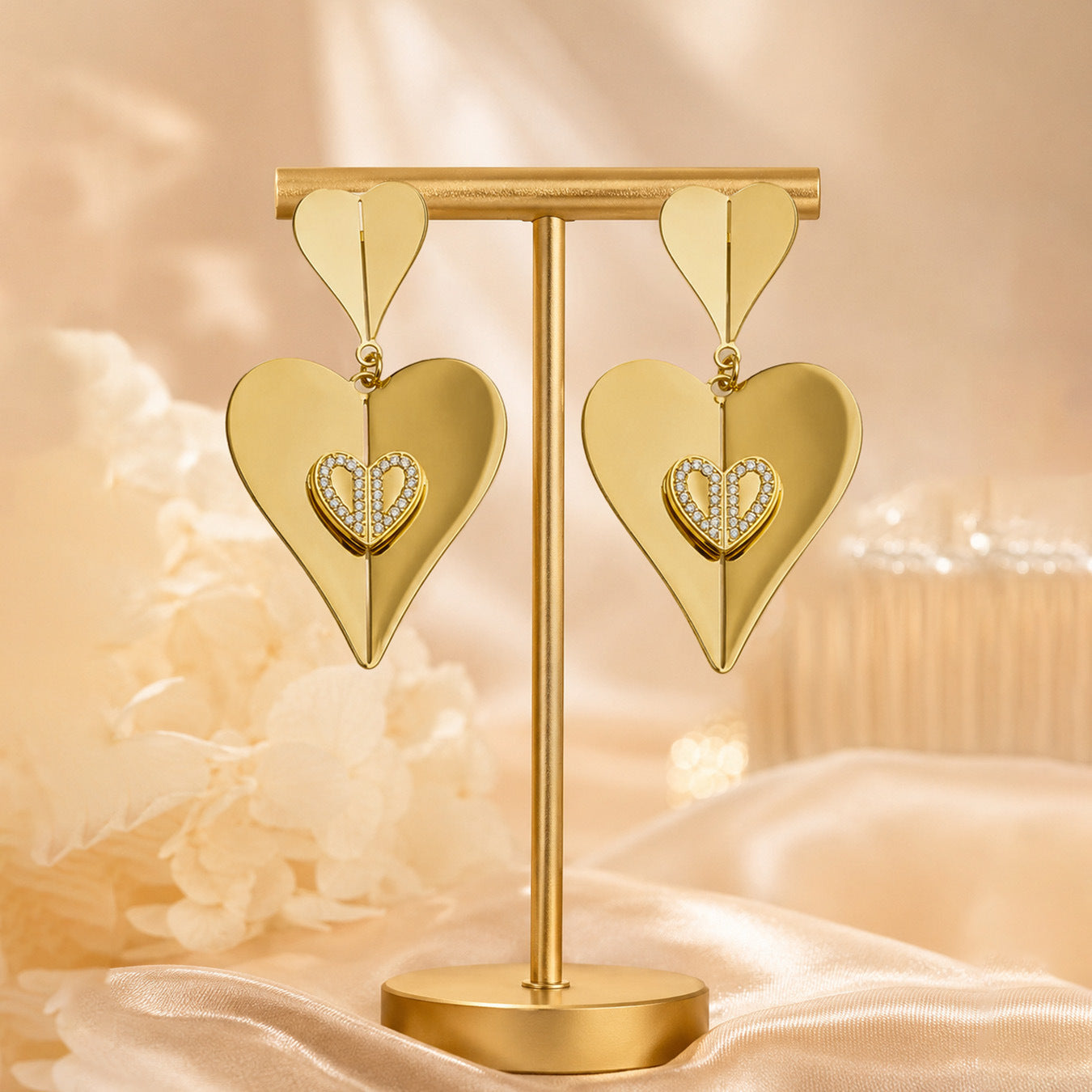 Gold heart zircon drop earrings displayed on stand with polished 18K PVD gold tone finish