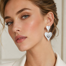 Model wearing steel heart zircon drop earrings in 316L stainless steel with sparkling heart pendant details