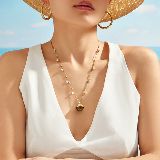 Model wearing gold tiger eye pendant necklace with statement stone charm for boutique jewelry styling