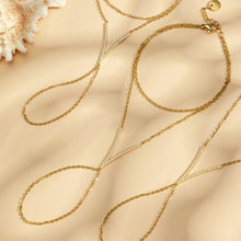 Gold zircon hand chain bracelet with V-shaped sparkling zircon bar and dainty finger-to-wrist chain, beach flatlay by Miduoduo Jewelry