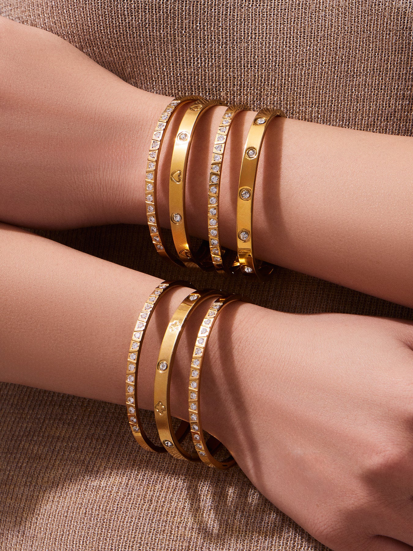 Minimalist gold bangles layered together on the wrists