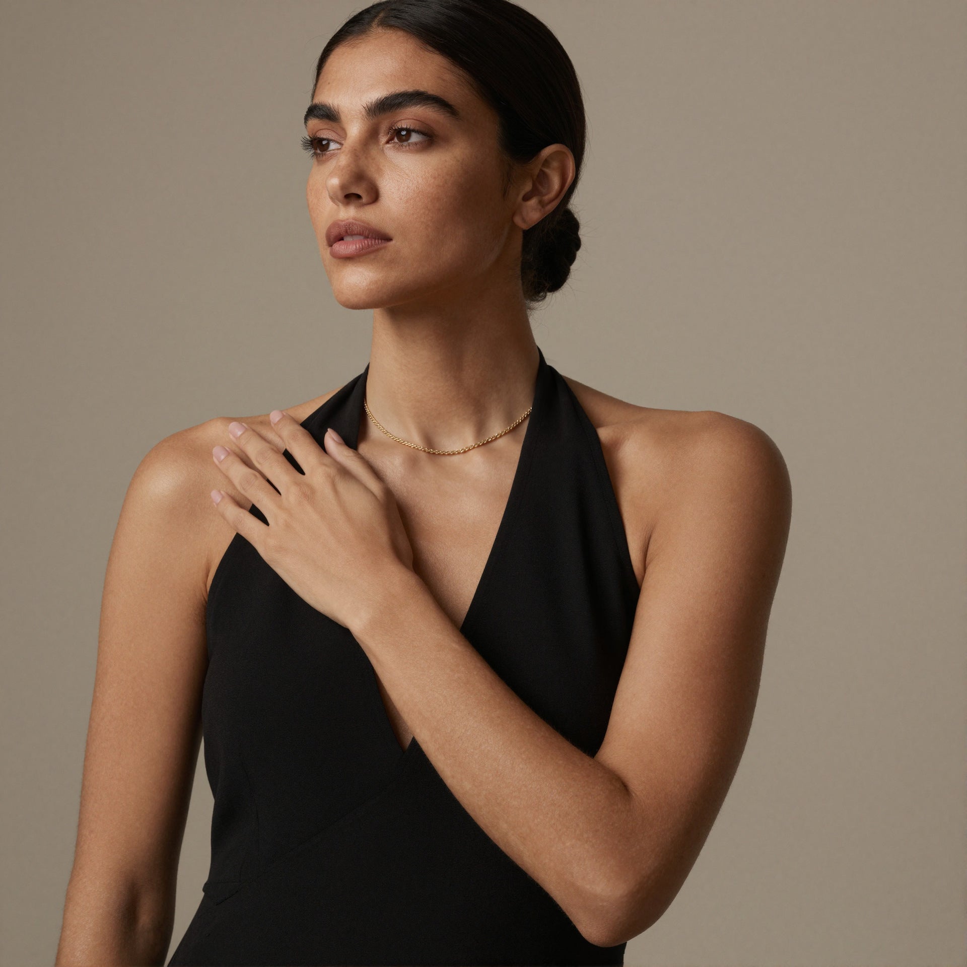 Close-up of gold rope chain necklace on model with black halter outfit for boutique necklace wholesale styling