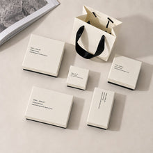 Minimalist white and black jewelry boxes arranged for boutique retail packaging display