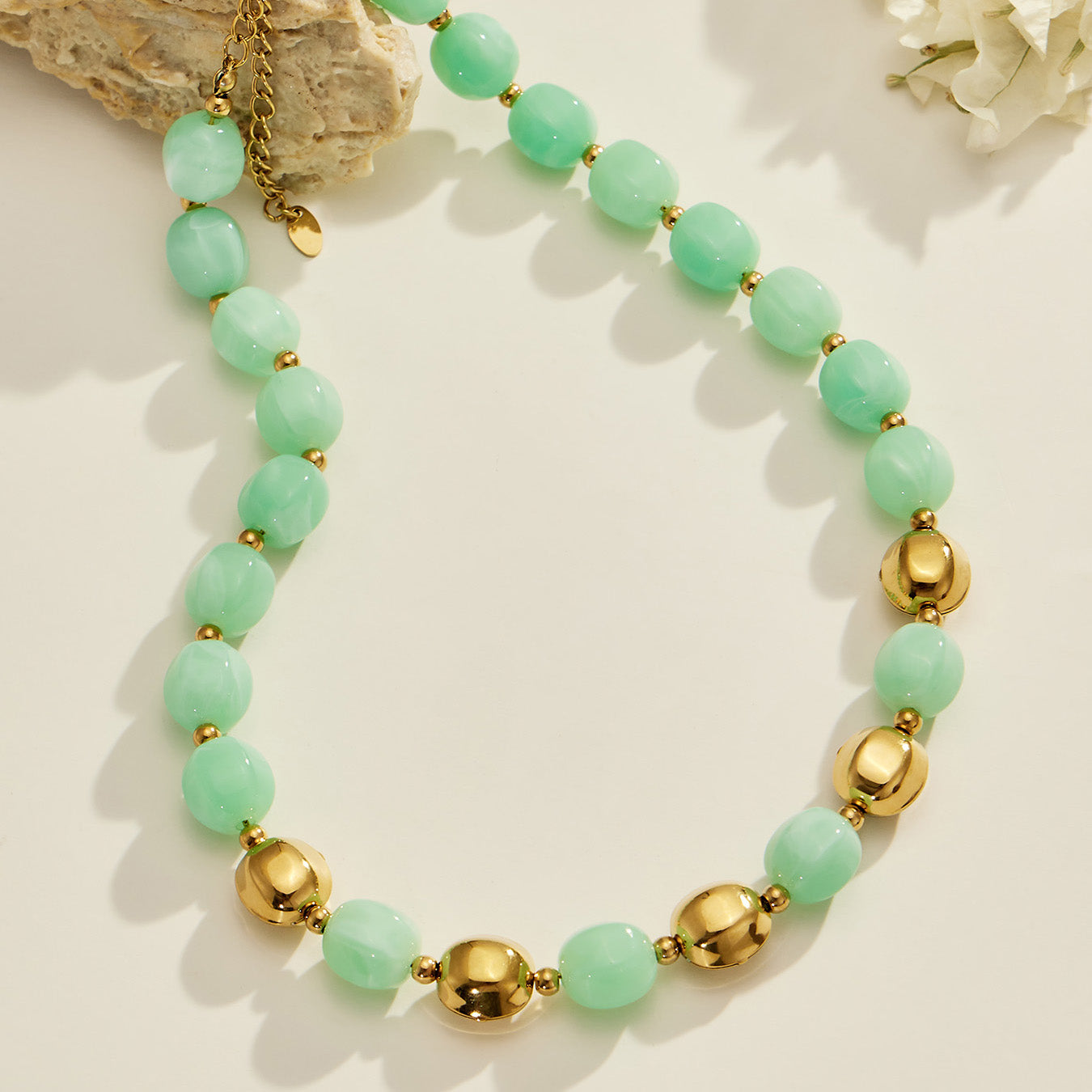 Flat lay of a mint green resin bead necklace with 316L stainless steel accent beads.