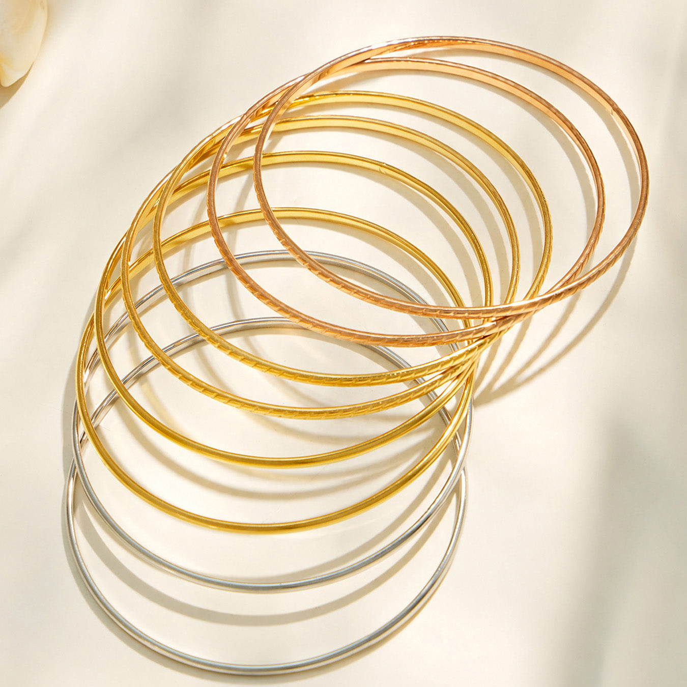 Slim stainless steel stackable bangles in steel, gold and rose gold-tone finishes