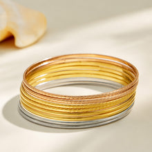 Stacked display of slim steel, gold and rose gold-tone stainless steel bangles