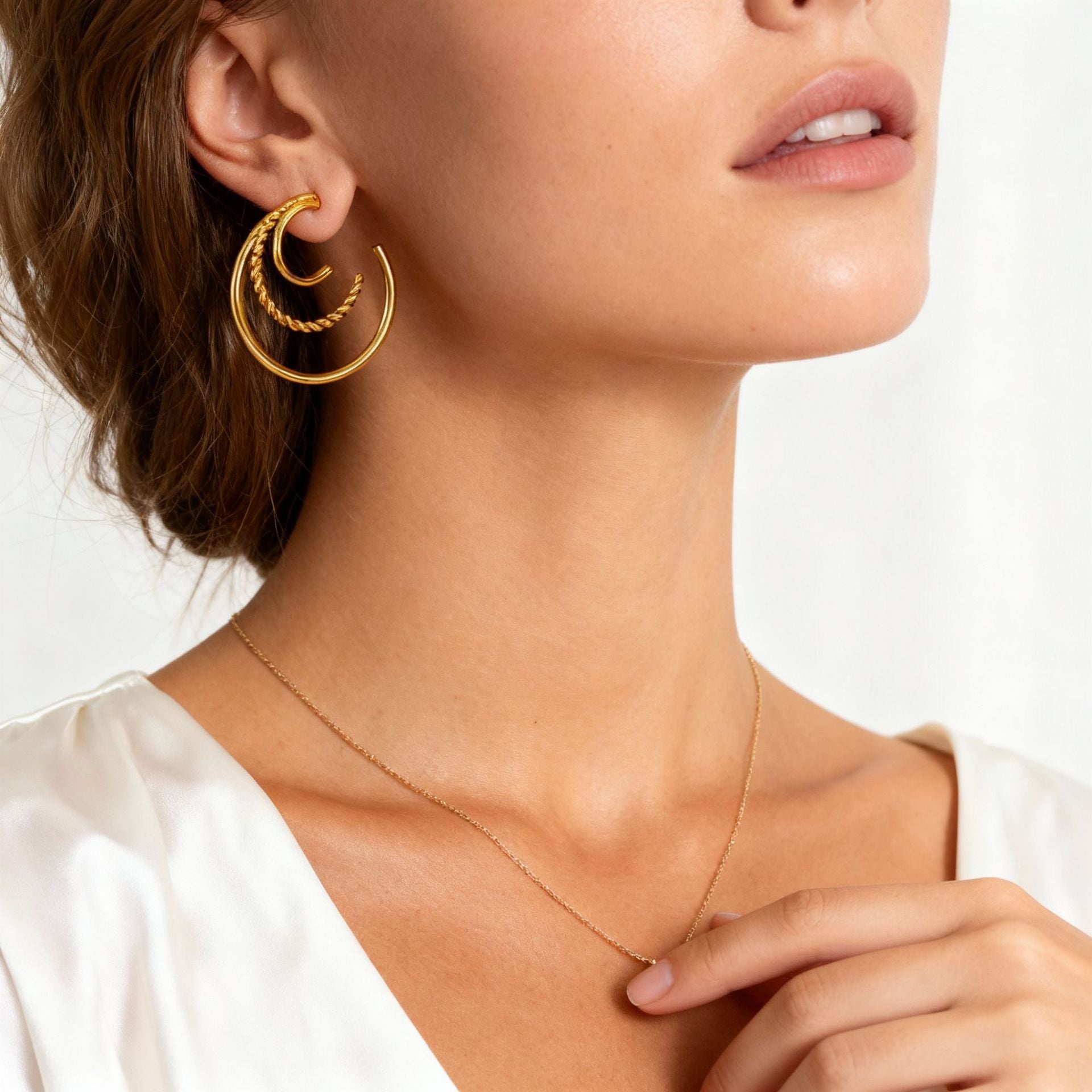 Close up detail of triple hoop earrings on ear showing twisted rope texture and quality finish.