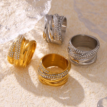 Gold and steel multi-row cubic zirconia statement rings in a styled flat lay