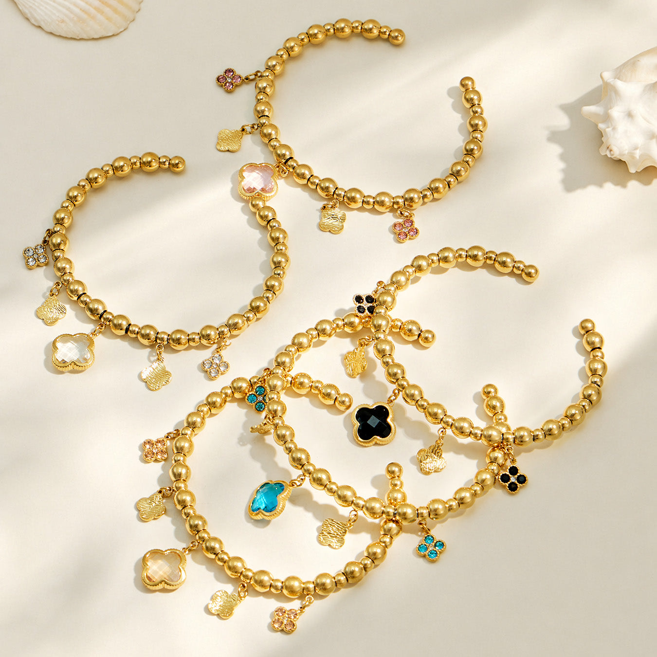 Gold four-leaf clover charm bracelet assortment in white, pink, black, blue and champagne