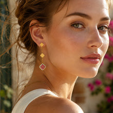 Gold clover drop earrings with multicolor crystal details worn by a model