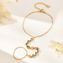 Multicolor CZ hand chain bracelet with gold-tone chain, finger loop and adjustable extension laid flat