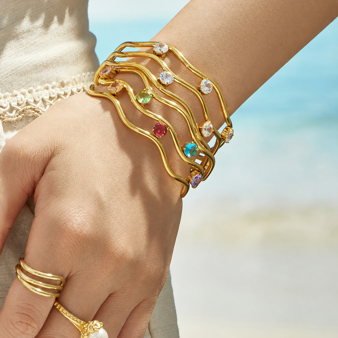 Model wearing a multicolor cubic zirconia three-layer open bangle