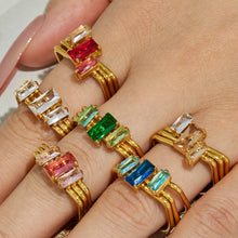 Multiple colorful CZ statement rings in white pink green and blue styled on a model hand