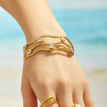 Lifestyle view of a multicolor cubic zirconia three-layer open bangle