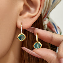 Model wearing colorful glass stone drop earrings in a modern geometric design