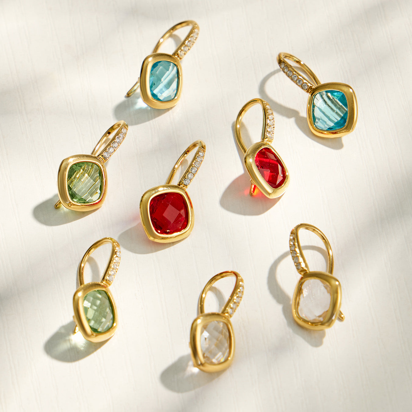 Collection of colorful glass stone drop earrings in multiple jewel-tone colors