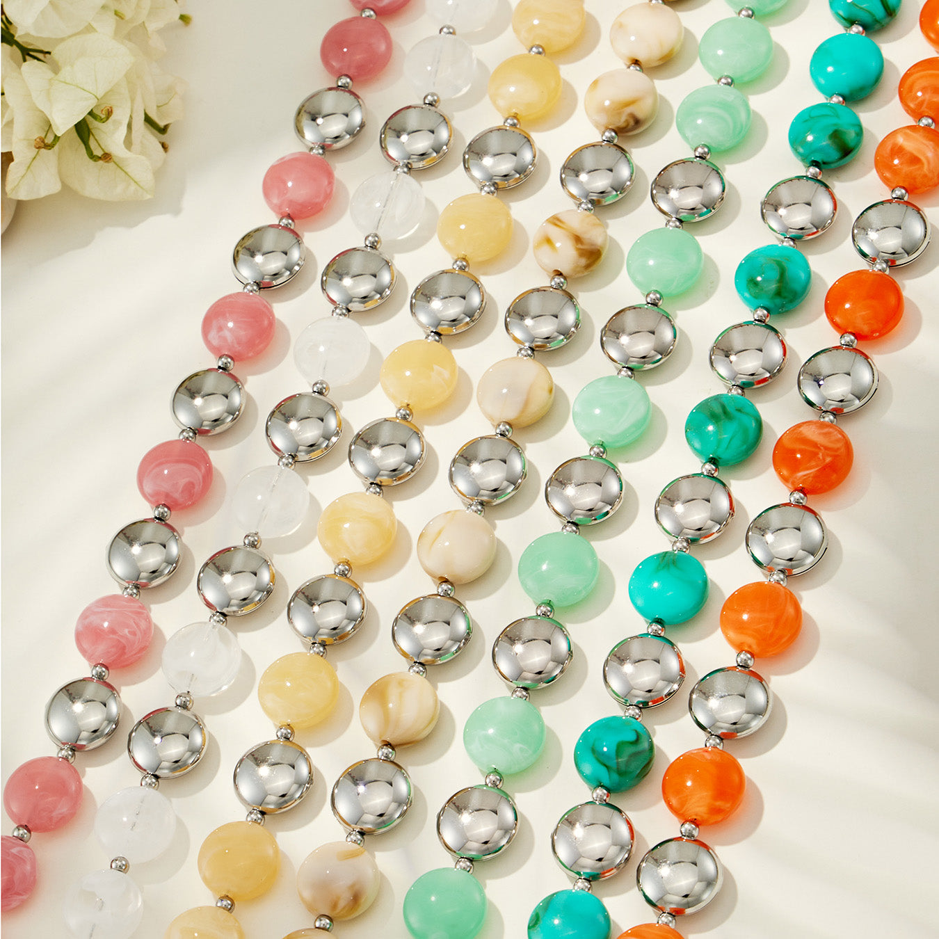 Flat lay assortment of colorful resin bracelet and necklace styles in multiple fashion color combinations.