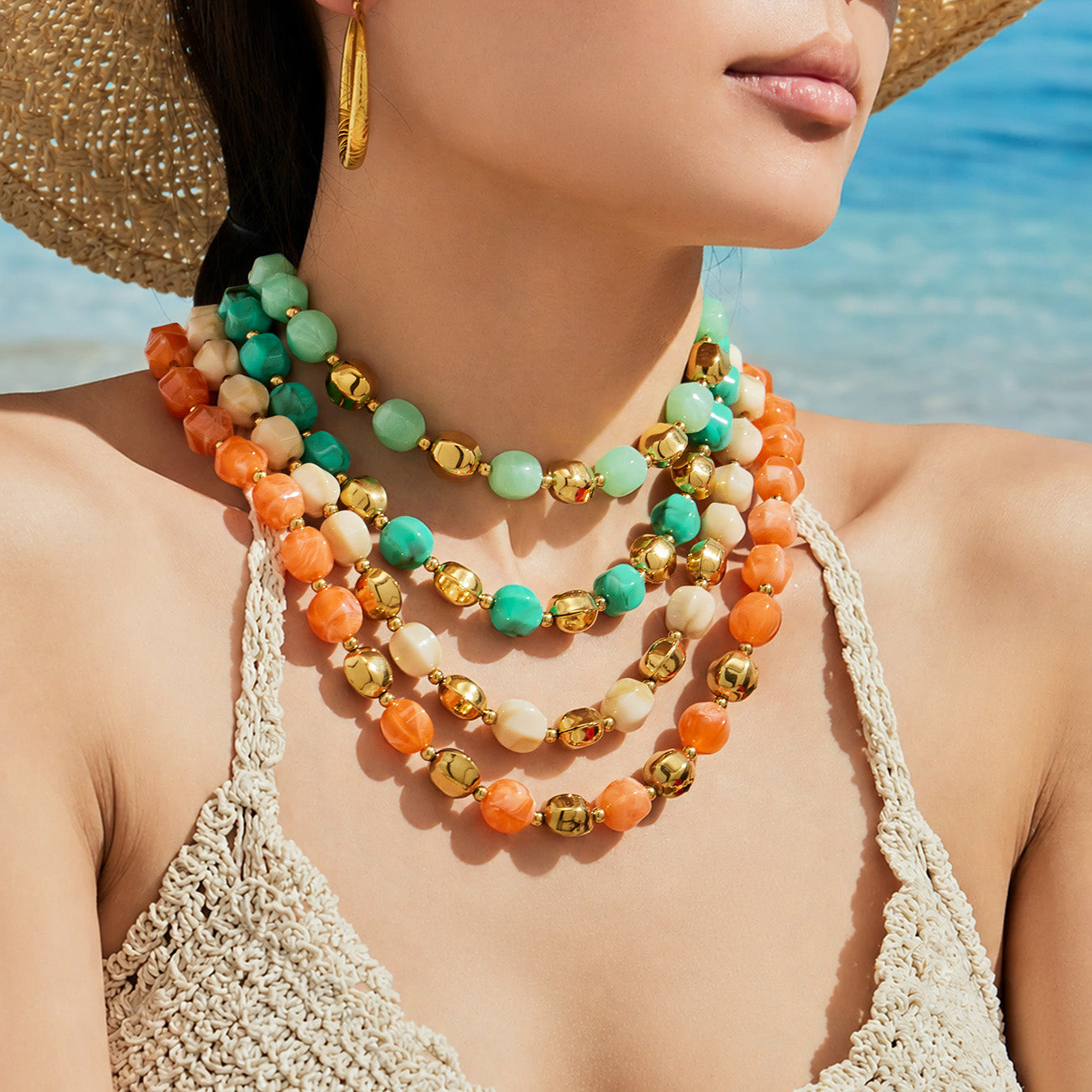 Model wearing layered multicolor resin bead necklaces and matching bracelets in a bold statement styling look.