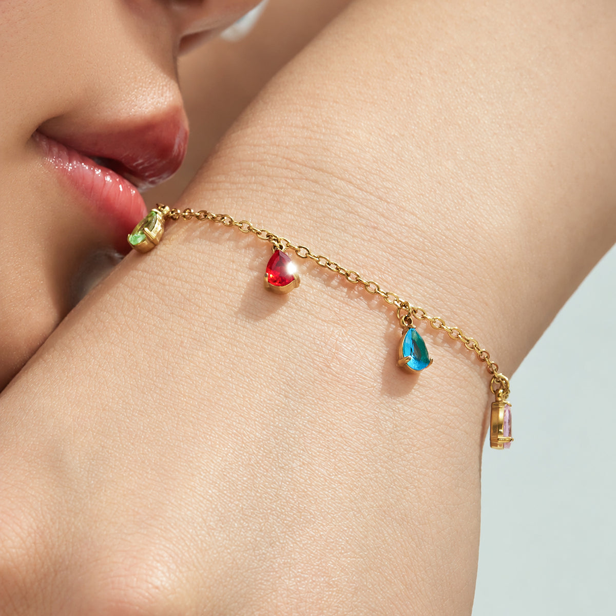 Gold-tone multicolor teardrop zircon bracelet worn on the wrist
