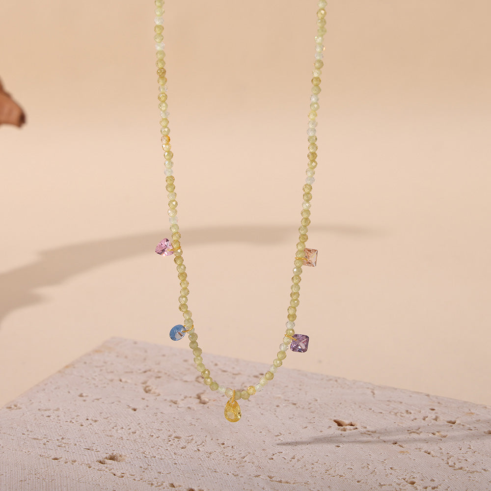 Gold natural stone beaded necklace displayed on a light jewelry presentation background