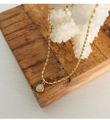 Natural stone pendant necklace with 18K PVD gold finish styled in a warm lifestyle jewelry display