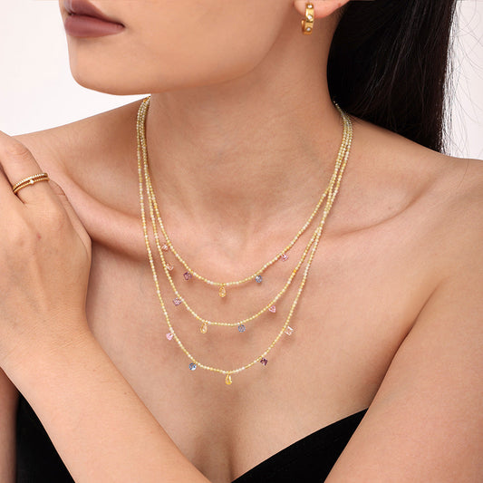 Model wearing a layered natural stone beaded necklace with 18K PVD gold stainless steel chains