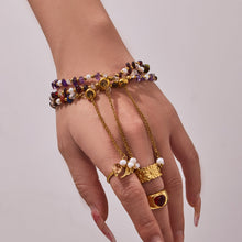 Model wearing a multi-row natural stone and freshwater pearl bracelet with rings