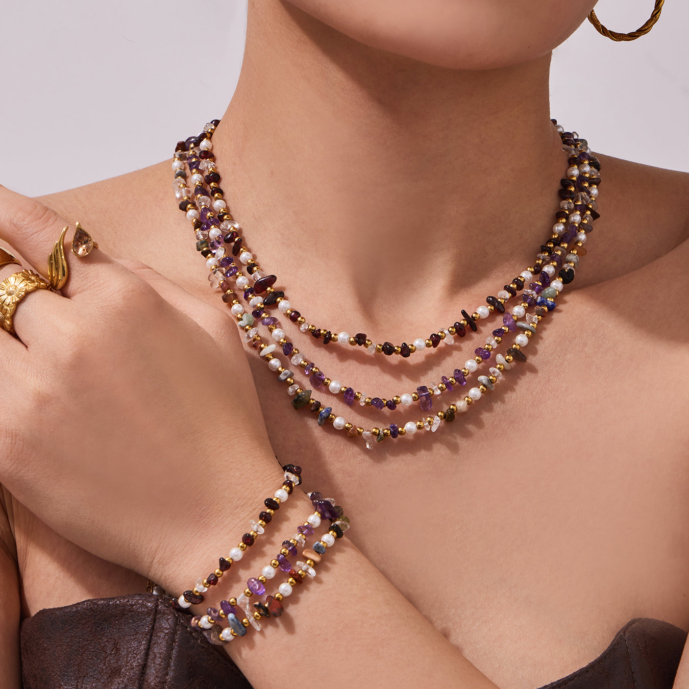 Model styling a multi-strand natural stone and freshwater pearl necklace