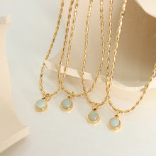Multiple natural stone pendant necklaces with gold stainless steel chains displayed together for boutique presentation